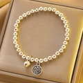 Silver bead bracelet with Fu character pendant and small bell on a gold gift box - Silver Fortune Bell Bracelet (X756)