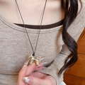 Detailed view of a golden pony pendant on a black cord worn by a model for daily style - 17# Necklace Gold Black Cord Pony