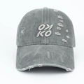 Détail du tissu gris délavé avec broderie OX KO et finitions déchirées de style vintage - Gris