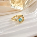Primer plano de anillo abierto dorado con luna azul y micropavé de piedras coloridas - Estrella Luna Piedra Azul Claro (JZ0111)