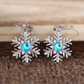 Elegant snowflake drop earrings with blue moonstone and silver finish for winter style - White Gold