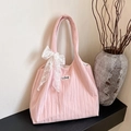 Pink pleated tote bag with white lace bow and LOVE patch in minimalist setting - Pink