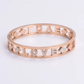Detalle macro del brazalete LOVE calado en oro rosa con brillantes cristales blancos - Oro rosa