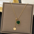 Golden titanium necklace with emerald heart pendant and Love tag on gray jewelry box - Adjustable Heart Green Stone Gold