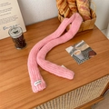 Minimalist pink knitted long scarf with a vegetable label on a rustic wooden background - Pink