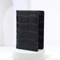Slim bi-fold card holder wallet in black crocodile embossed leather on a podium - Black