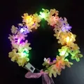 Macro shot of glowing LED floral headband with pink lilac flowers and colorful lights - Yellow