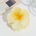 Macro shot of a warm yellow gradient egg flower hair claw clip on a lifestyle desk background - Plumeria Claw Clip Yellow