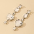 Makro-Detail langer geometrischer Ohrringe mit Strass-Herz und rechteckigen Tropfen - Lange Herzohrringe mit 925er Silbernadel / Silberne Herzohrringe