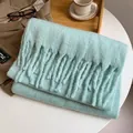 Dicker mintgrüner Mohair-Schal mit Fransen auf einem Tisch mit Winter-Accessoires - Minzgrün