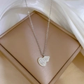 Detailaufnahme der silbernen Doppelherz-Halskette mit Zirkon-Pavé auf beigem Display - Doppelherzform (K502 Silber) / Silber