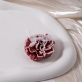Detail of red carnation scented candle with white bow on a ceramic tray home decor - Dark Red