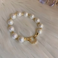 Détail d'un bracelet en perles plaqué or avec un fermoir serti de zircons brillants - Or