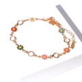 Makro-Detail des Goldarmbands mit bunten Emailleblumen und funkelnden Kristallen - Bunte Gänseblümchen Gold