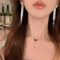 Silver heart tassel earrings and black butterfly necklace set worn by a female model - Silver Heart Tassel Set