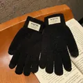Thick black knitted touchscreen gloves with warm ribbed cuffs and decorative label - Black