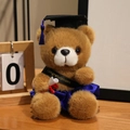Brauner Absolventen-Teddybär in blauem Talar mit Glückwunsch-Schärpe und Urkunde - Dunkelbrauner Bär-Dunkelblaue Kleidung / 18cm