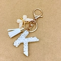 Letter K keychain with white resin stones, gold foil, white tassel and butterfly charm - Letter K