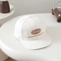 Detailaufnahme der braunen Stickerei auf der beigefarbenen Baumwoll-Hip-Hop-Cap - 52-54cm (3-8 Jahre) / Weiß