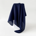 Detailed macro view of deep blue pleated fabric texture on a minimalist white cube pedestal - Navy Blue