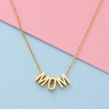 Polished gold MOM letter pendant necklace for women on a colorful background - Gold