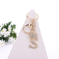 Golden letter S crystal keychain with crown pendant on white display stand - Letter S / Gold