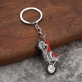 Creatieve metalen motorfiets sleutelhanger met rood zadel op getextureerde achtergrond - Rood