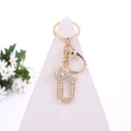 Golden crystal letter U keychain with crown and sparkling rhinestones on white stand - Letter U / Gold