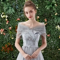 Detalle de vestido de fiesta gris con hombros descubiertos, bordado floral y capa de tul - Gris