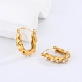 Close-up of golden U-shaped earrings with hammered texture and small pearls inlay - Golden U-shape Pearl