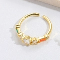 Macro shot of gold adjustable ring featuring sparkling clear and colored gemstones - Square Green Zirconia