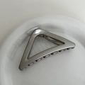 Macro detail of a grey matte metal triangle hair claw clip on a white ceramic plate - Grey Silver - Large Triangle