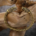 Goldenes Wikinger Drachenkopf Armreif mit geflochtener Textur auf rustikalem Holz - Gold