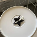 Detail of a star-shaped black hair clip with white polka dots on a minimalist stand - Black Polka Dot Star Style (HDJ-11) / White Traceless Clip / White