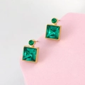 Detailed close-up of emerald green square stud earrings with polished gold finish - Green