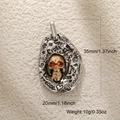Détail du pendentif crâne gothique avec yeux en gemme orange et gravure sur métal bicolore - Crâne Argent Antique 1