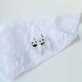 Macro shot of cute ghostly resin charms with gold hangers on white textured paper - Frosted White Ghost