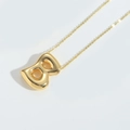 Macro shot of mirror-polished gold balloon letter 8 pendant on a fine necklace chain - Letter B