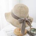 Detail of beige straw sun hat featuring brown plaid ribbon and white lace trim bow - Adjustable / Beige