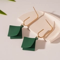 Dettaglio di orecchini geometrici verde scuro con ganci dorati su un vassoio bianco - Ago d'argento / Orecchini Pendenti Geometrici Verniciati Verde