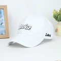 Detail of white cotton baseball cap featuring 3D Revise and Latest embroidery on a desk - Adjustable / White