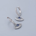Macro shot of silver evil eye earrings with blue crystals and sparkling zircons - Evil Eye Earrings - Silver