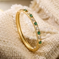 Brazalete bañado en oro 18K con piedras verdes y trébol de esmalte sobre fondo tejido - Oro-Verde