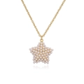 Elegant gold tone star pendant necklace featuring pave set pearls on a delicate chain - Gold Star Necklace