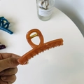 Détail d'une pince à cheveux en acrylique ambré tenue à la main sur un fond décoratif - Orange Foncé Transparent-Moyen Droit-Boucle Papillon (9cm)