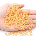 Golden bow-shaped resin beads for DIY hair accessories and handmade crafts, shown in hand - 60 Pieces / Gold