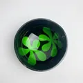 Polished dark coconut shell bowl with green floral pattern inlay for home decor - Green Petal Style