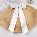 Elegant large white satin bow hair clip with long ribbons on a textured decorative tray - Duckbill Hair Clips / White