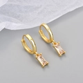 Detail view of gold huggie earrings with emerald cut champagne zircon drop charms - Copper / Yellow Gold with Champagne Zircon