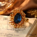 Macro shot of vintage gold ring with large oval blue gemstone and colorful accents - Blue Gemstone Vintage Ring (2-19652A-JC-6200)